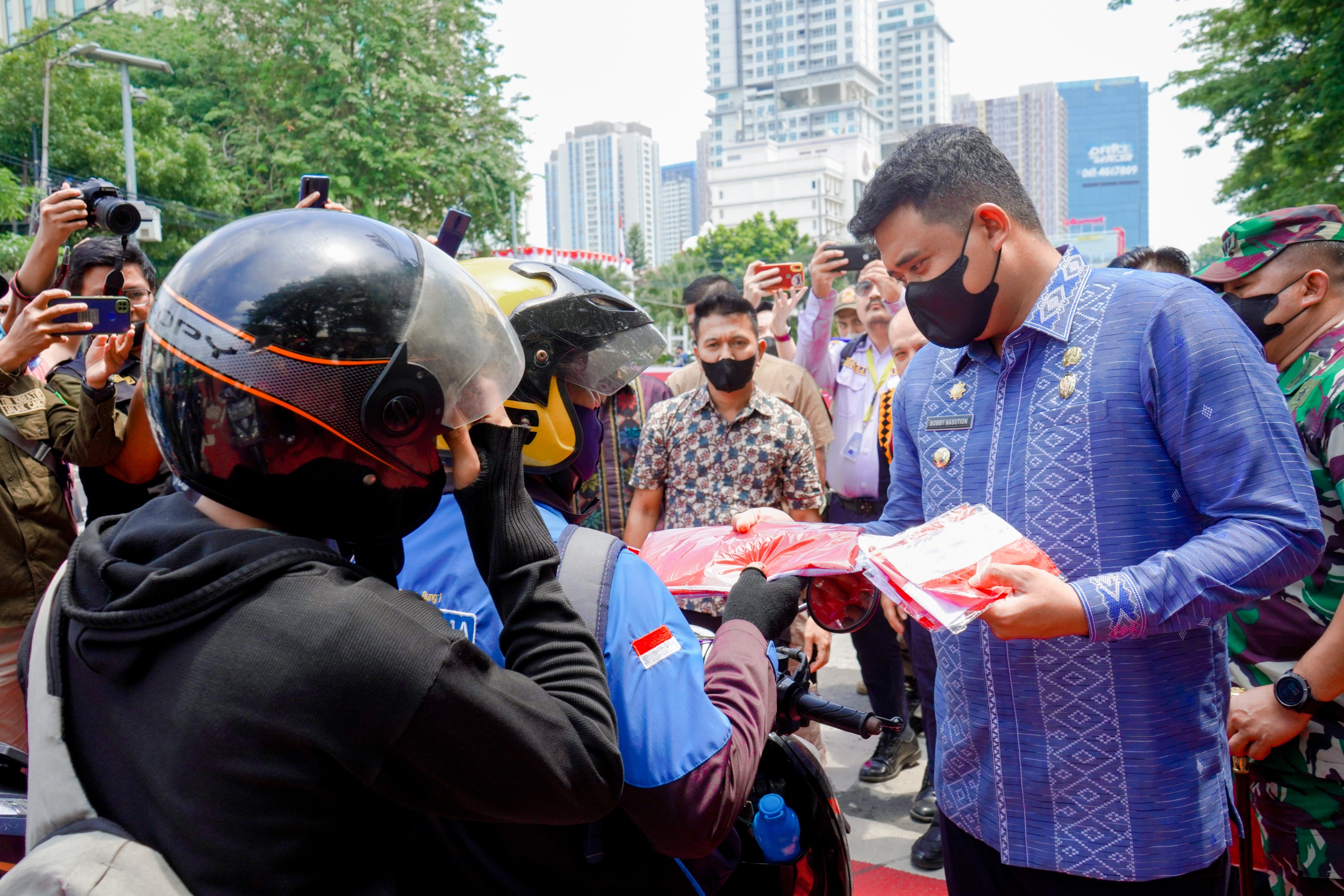 Wali Kota Medan, Bobby Nasution Membagikan Bendera Merah Putih Kepada Masyarakat Yang Nelintas di Jalan Balai Kota Medan, Jumat (5/8)
